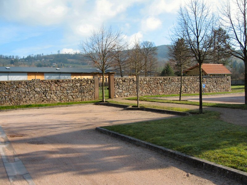 DerriÃ¨re le monument aux Morts, le mur du Verger Patrimonial.