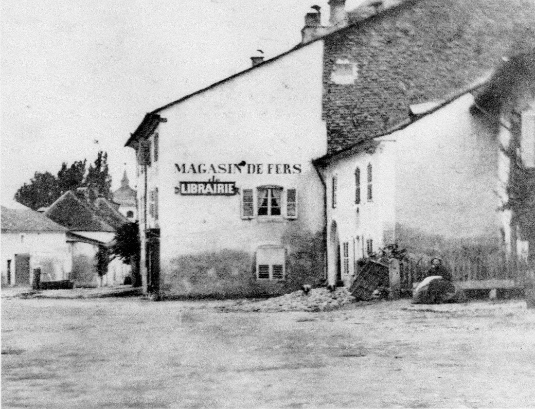 La maison de Joseph Deloisy porte l'inscription Magasin de Fer<br>La petite maison à droite qui appartenait à un certain Nicolas Aubert a été détruite en 1870, pour faciliter l'accès à l'hospice.
